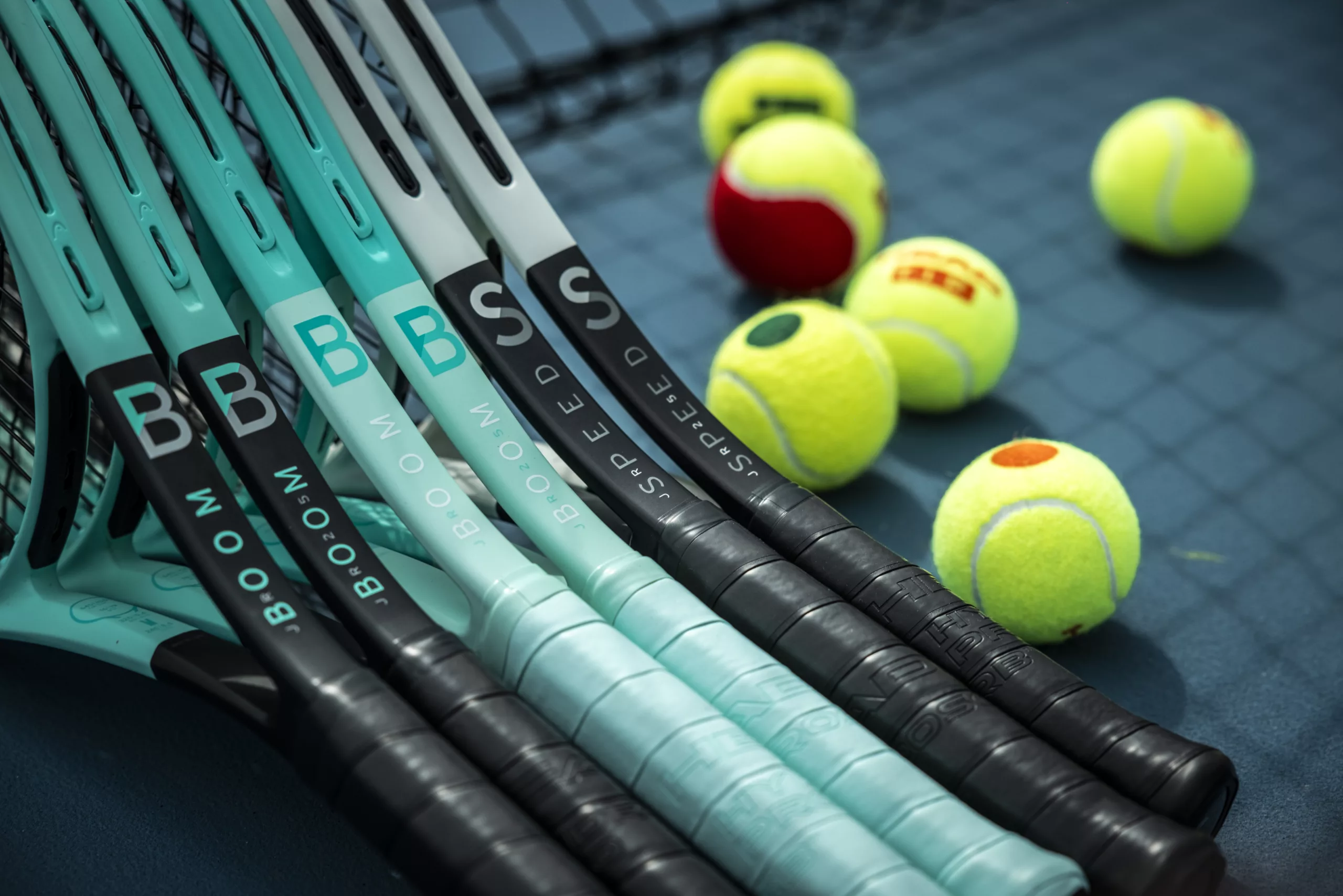 HEAD Tennis rackets with balls on court.