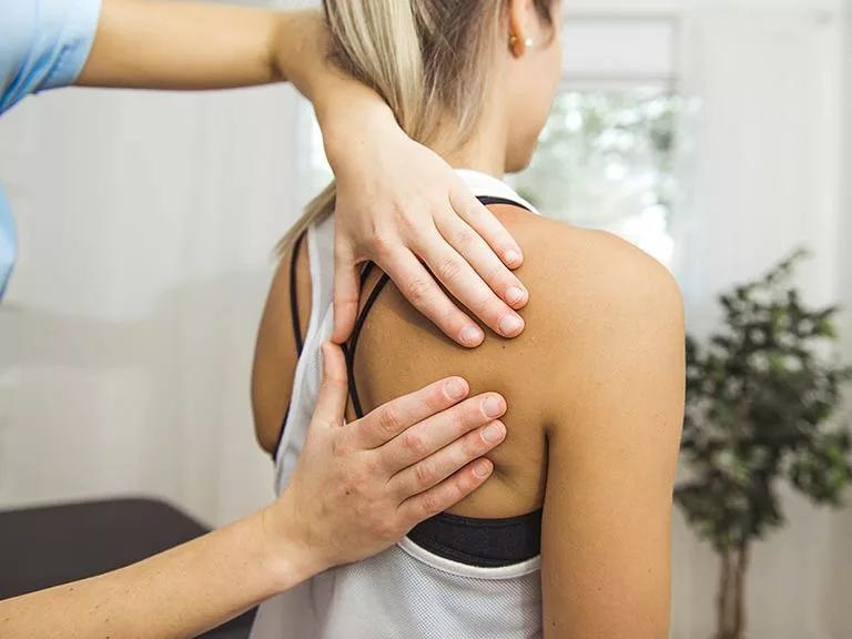 physiotherapist working on woman's shoulder
