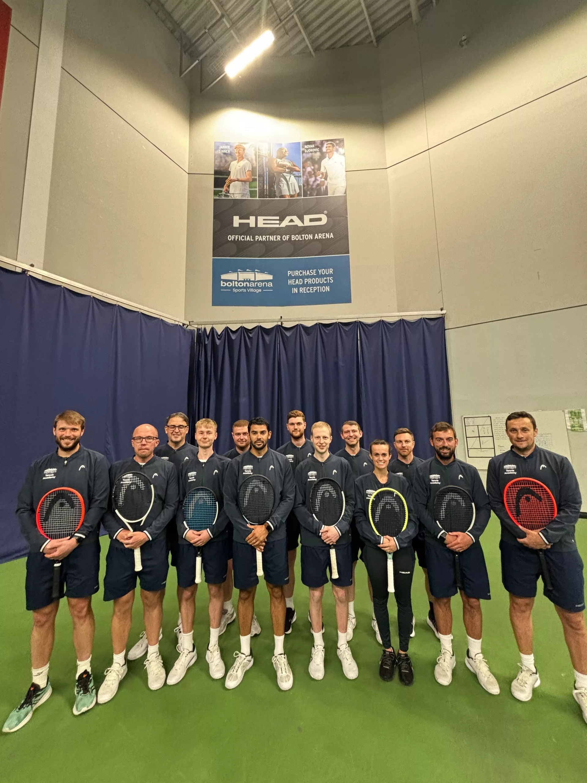 Tennis team all holding HEAD Tennis rackets in our tennis courts.