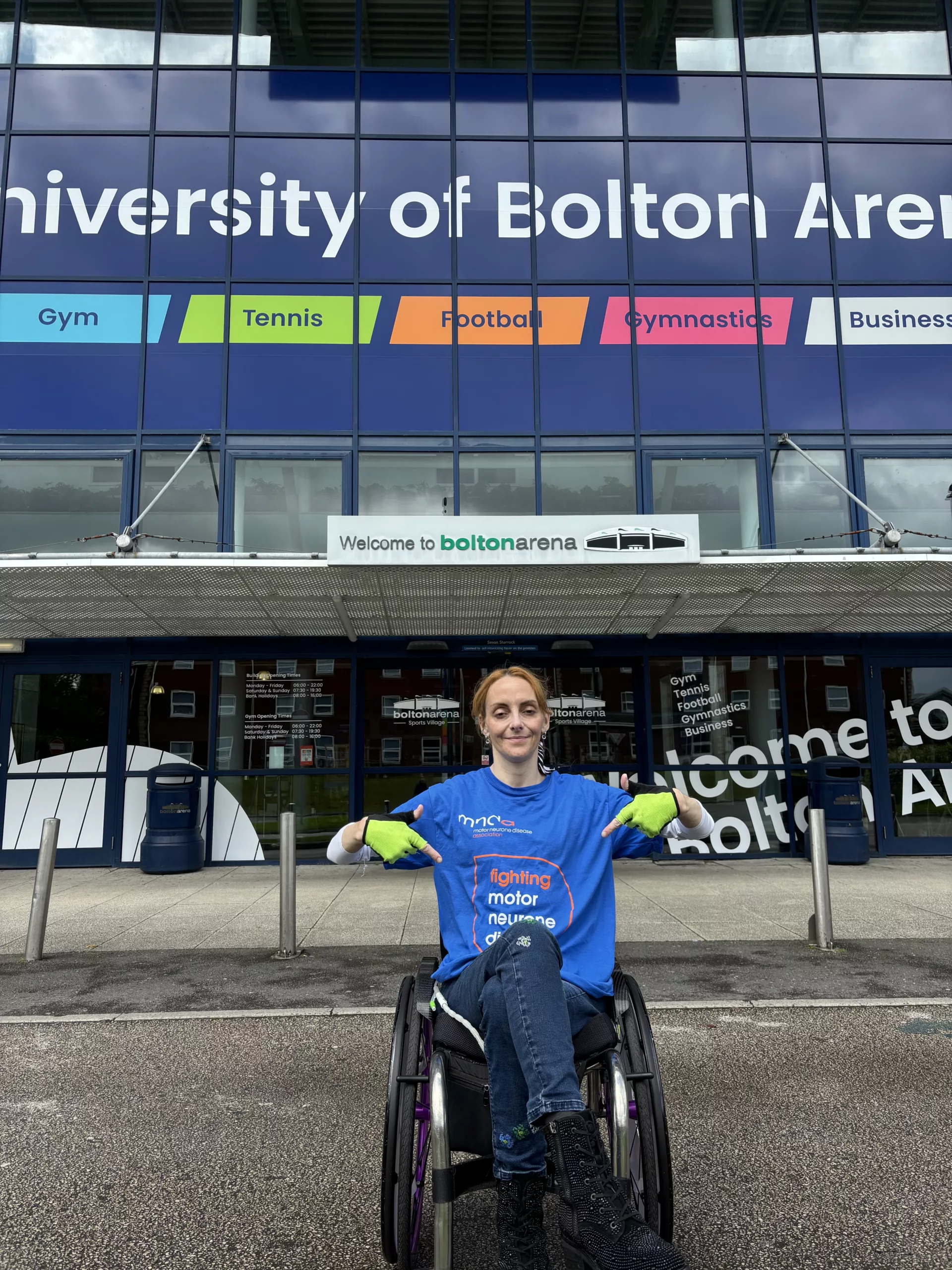 Natalie Amber outside Bolton Arena, pointing are her MND top.