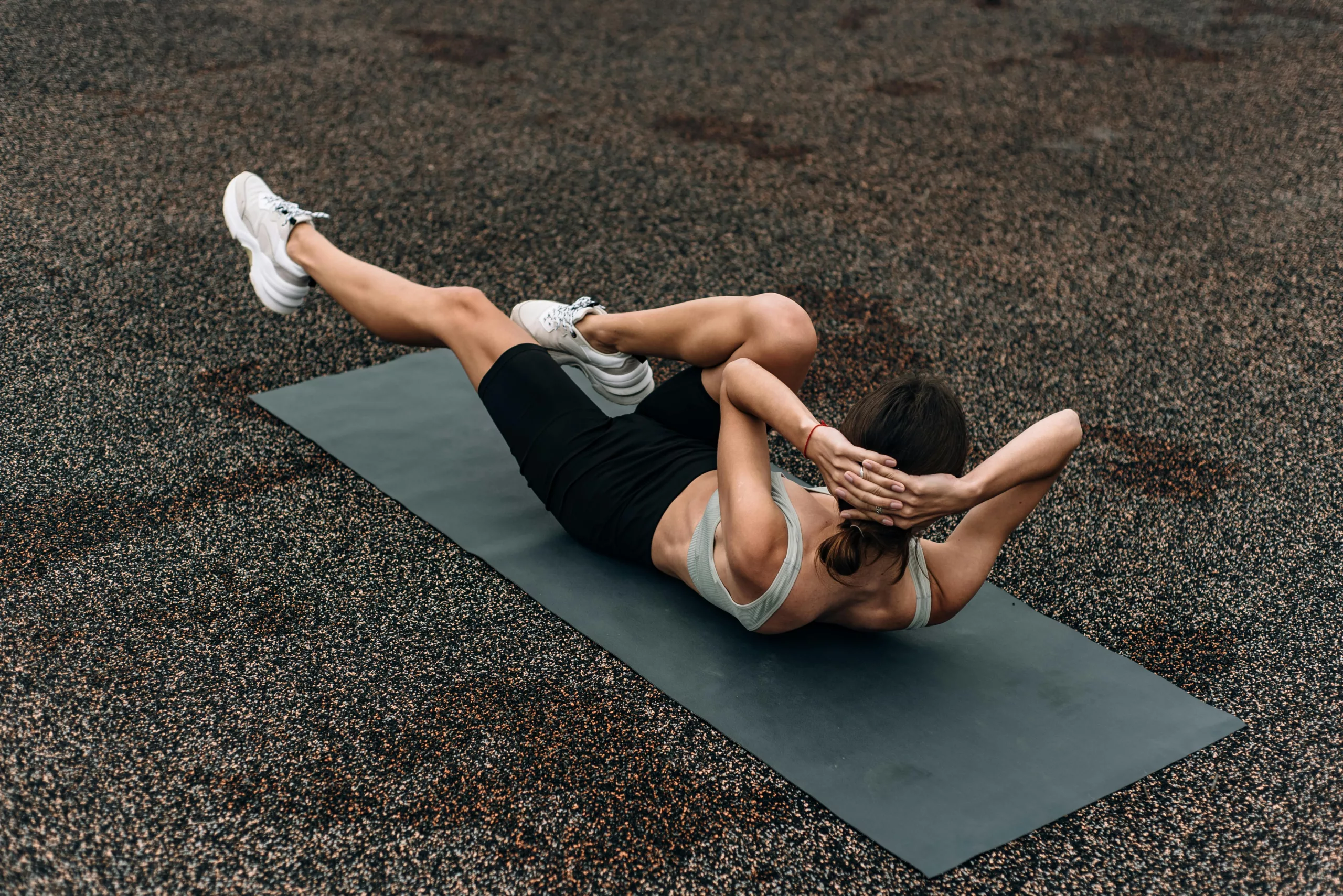 Woman doing a bicycle crunch on a gym mat