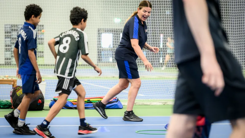 Active Bolton Coach running alongside kids in holiday camps.