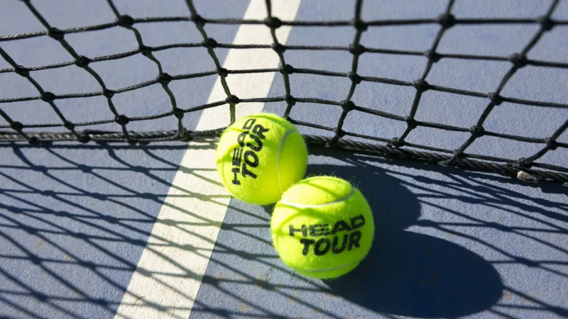 Two tennis balls on hard tennis court