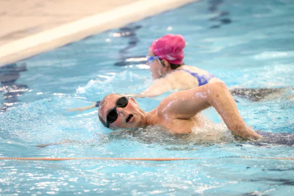Swimmers enjoying lane swimming in a pool.