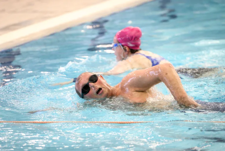 Swimmers enjoying lane swimming in a pool.