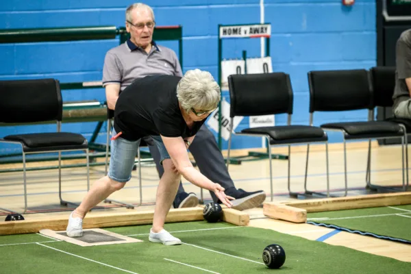 Woman bending down to deliver bowls at Active Bolton Horwich