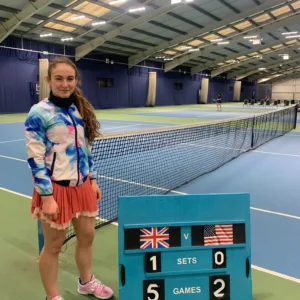 Girl stood next to indoor tennis court at Active Bolton Arena