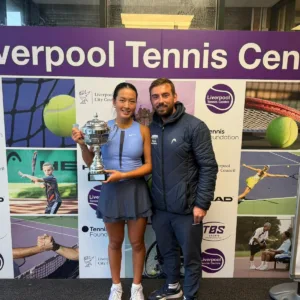 Girl holding trophy with coach at Liverpool Tennis Centre