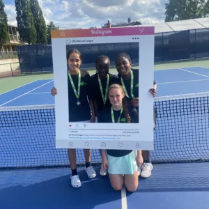 Girls stood on tennis court