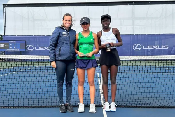 Head of regional player development centre at Active Bolton Arena stood at net on court with two female tennis players
