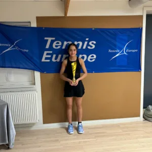 Girl stood holding tennis europe trophy